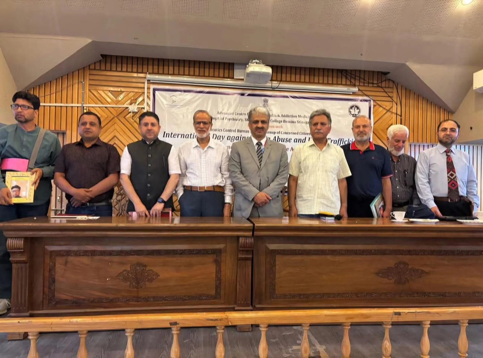 Mental-health and public-health collaborators standing together at a formal programme